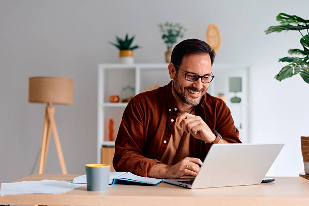 istock Happy man working remotely on laptop at modern home office 2250778755