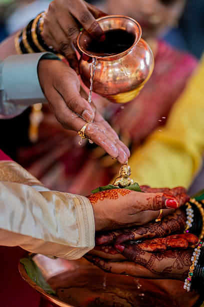 istock Hindu wedding ritual holding Krishna idol in decorated mehendi hands 2250781095