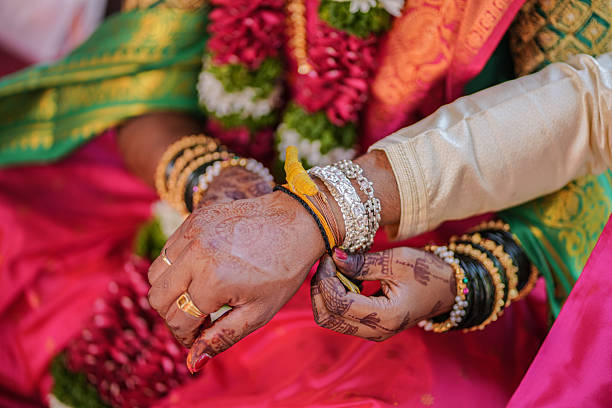 istock Traditional Indian wedding ritual tying sacred thread on bride’s wrist 2250781119