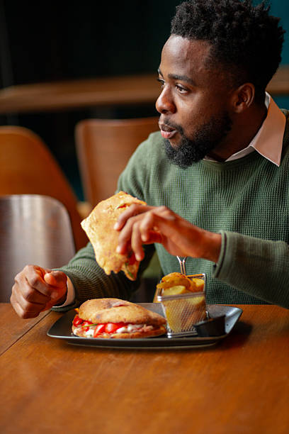 istock Young African American man eating in cafe 2250789651