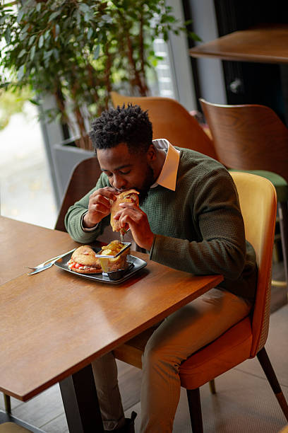 istock Young man eating lunch in trendy cafe 2250789653