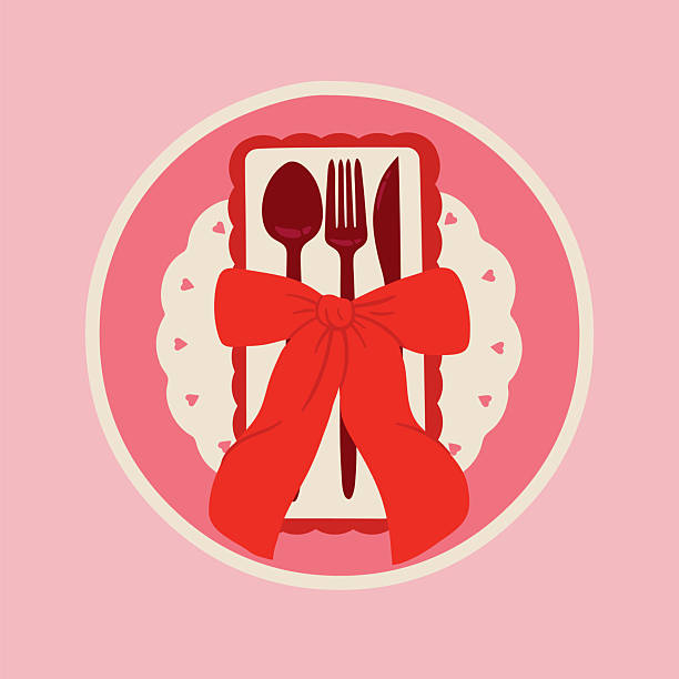 Cutlery setting for Valentine's Day or romantic dinner with red bow on a pink background