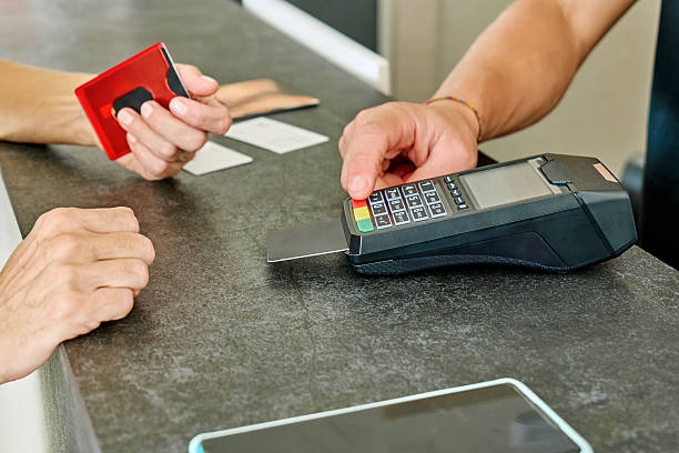 istock Unrecognizable woman completing a payment with a credit card at reception desk using a POS terminal for transaction 2250791978