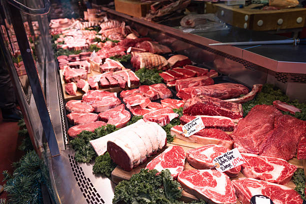 Fresh raw meat display at a butcher stall in Borough Market, London. High-quality cuts of beef and red meat arranged on the counter for sale. London, UK, 17 December 2023