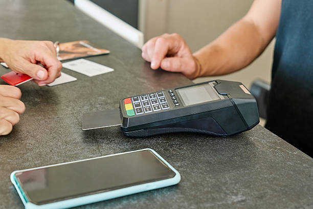 istock Unrecognizable woman completing a payment with a credit card at reception desk using a POS terminal for transaction 2250793605