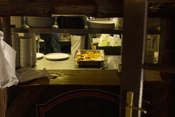 Behind the scenes of brands. The chef cooking in a professional kitchen of a restaurant meal for client or delivery. Open business from the inside. Meals during the quarantine. Hurrying up, motion.