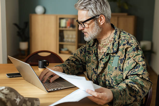istock Mature military veteran using a laptop and reviewing documents at home 2250798113