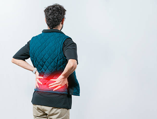istock Lumbar problems. Suffering male with pain holding his back isolated. Person with spine problems. Man with pain holding his back 2250798304