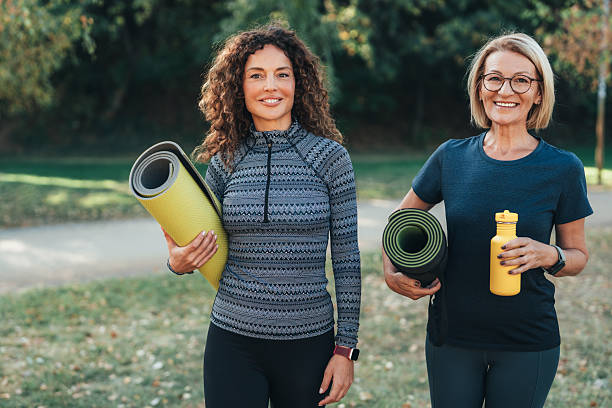 istock Friends holding exercise mats talking in the public park 2250800723