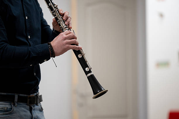 Close-up of musician's hands playing clarinet in orchestra