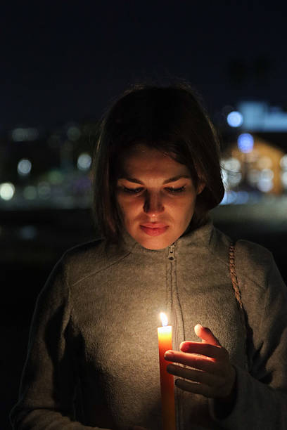 istock Woman holding burning candle expressing hope and remembrance 2250815400