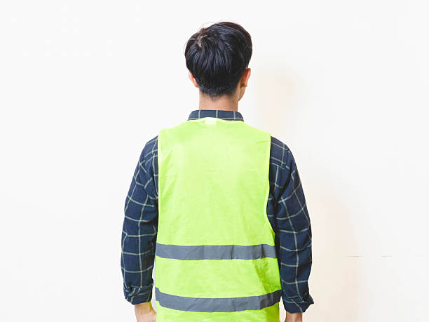 istock Worker in safety vest standing from behind on isolated background, suitable for concepts of supervision, inspection, monitoring, and workplace direction. 2250817461