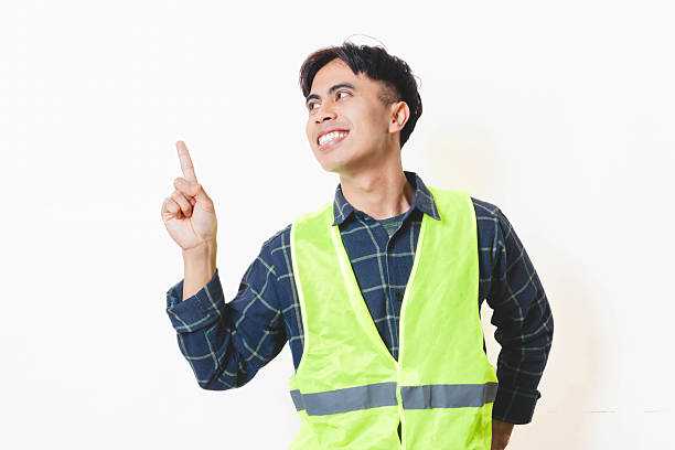 istock A construction worker wearing a safety vest smiling while raising one finger, showing an idea or giving a positive suggestion against a clean white background. 2250817641