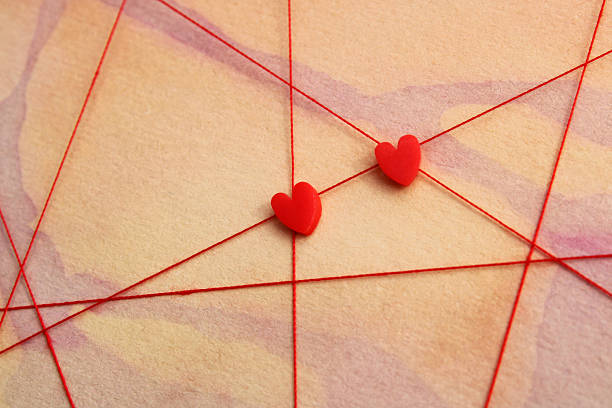 Red hearts on paths traced with a red thread, background with watercolor stains representing variety and difficulty