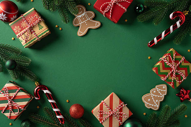istock Vibrant Christmas scene featuring wrapped gifts, candy cane, gingerbread figures, pine needles, and holiday ornaments arranged around a green backdrop 2250828861