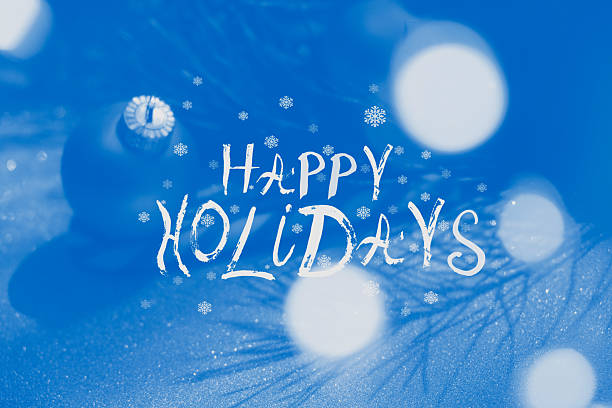 Happy Holidays saying, handwritten text. Snowflakes on soft blue background, light flares. Congratulating.  Merry Christmas and Happy New Year
