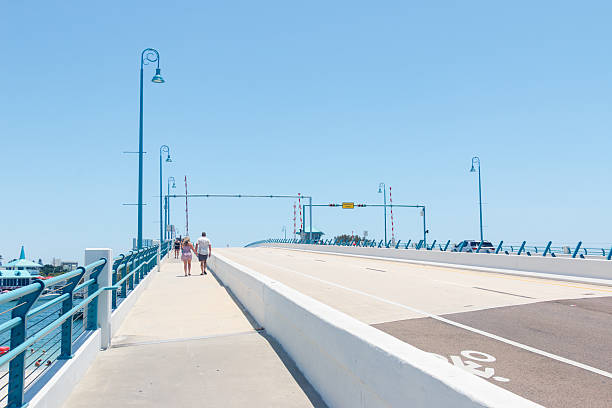 Pedestrians on the John's Pass bascule bridge at Madeira Beach, Florida, USA. The drawbridge is a landmark at Madeira Beach, connecting Treasure Island with Madeira Beach, the bridge is known for its frequent, demand based openings for shipping traffic.