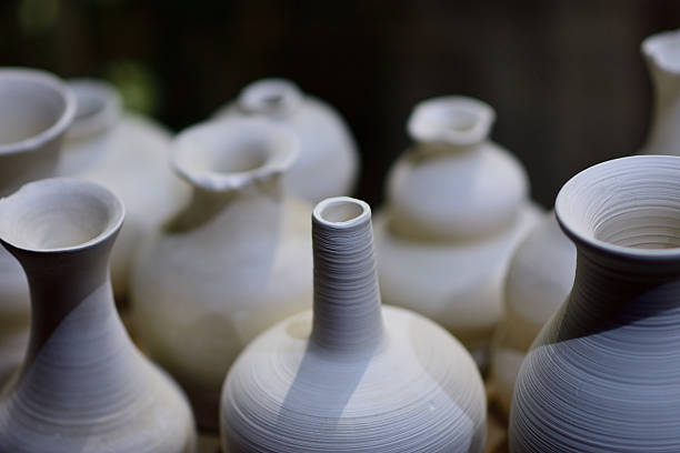 Close-up of white ceramic vases with smooth textures and varied shapes.