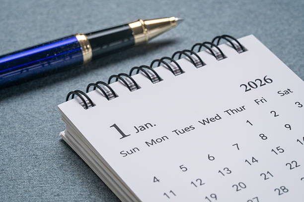 istock January 2026 - small spiral desktop calendar with a pen, time an 2250837404