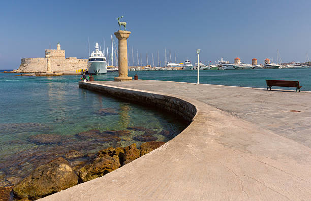 Medieval Fort Saint Nicholas with lighthouse at Mandraki harbor in Rhodes, Greece