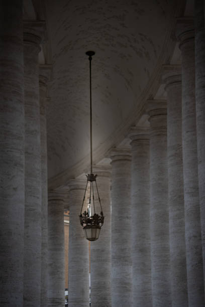Solitary lamp in the center of a colonnade creating a singular spotlight