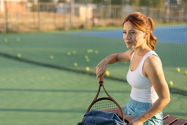 istock Focused female tennis player sitting courtside after match 2250840183