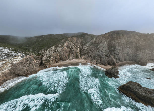 A raging sea crashes with its waves on the rocks that cross its path