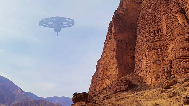 A futuristic alien structure floats above rugged rock formations, creating a surreal scene in the mountains.
