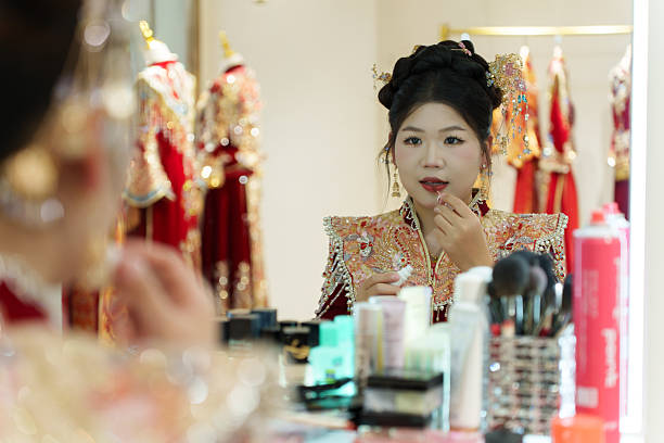 An Asian bride is having her makeup done.
