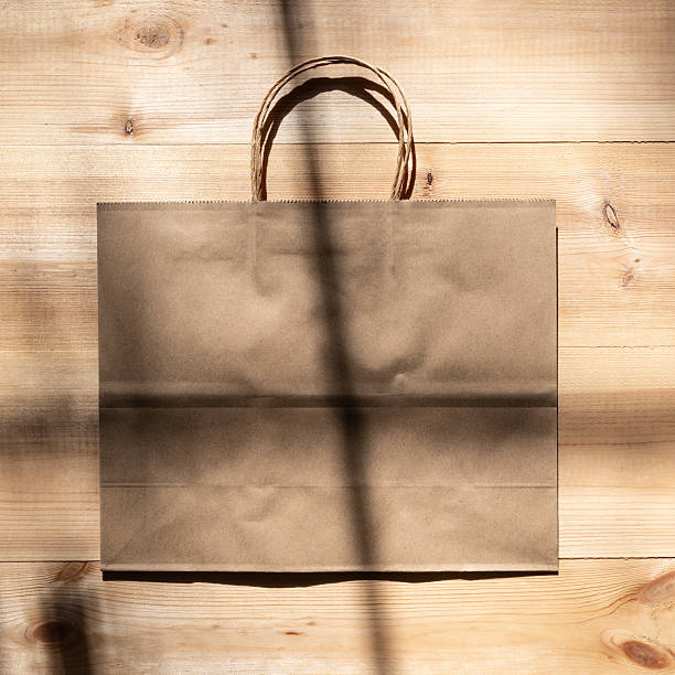 istock Paper bag on wooden boards in a light and shadow pattern 2250859021