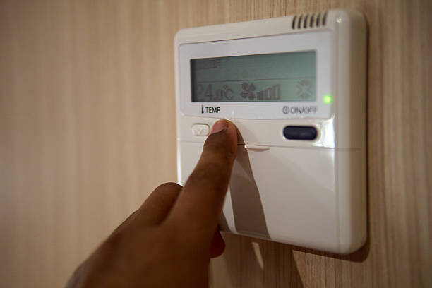 istock Finger Adjusting Digital Thermostat for Indoor Temperature Control 2250861280