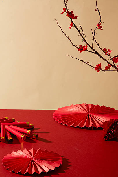 istock Minimal festive background with red paper fan and branch decor. Clean composition for text placement, product display and seasonal commercial visuals. Red tone for Chinese new year concept 2250865542