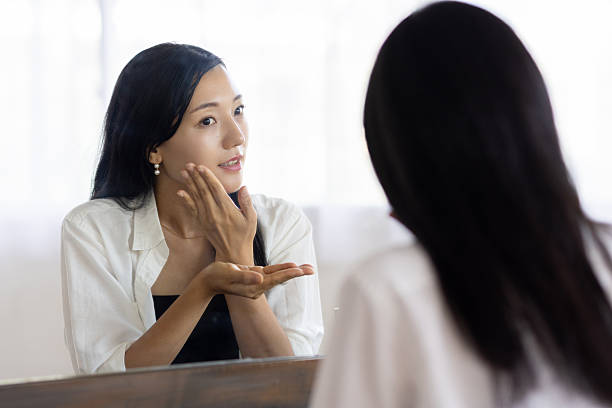 istock Woman Applying Lotion in Front of Mirror 2250866123