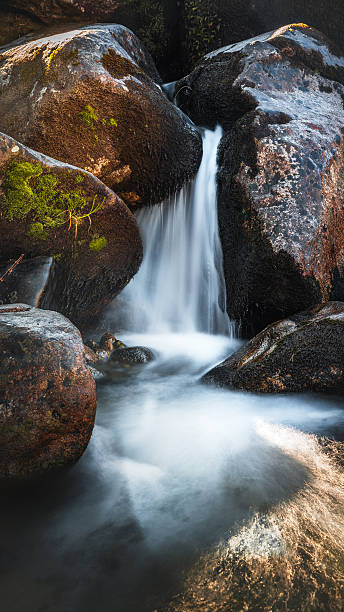 istock Close-Up Mountain Stream Waterfall over Mossy Rocks 2250866312