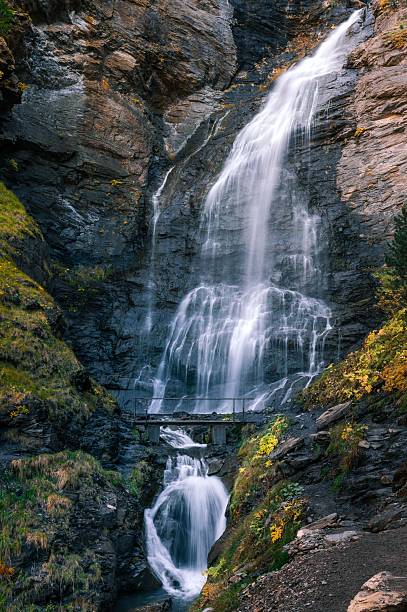 istock Tall Mountain Waterfall Flowing Over Rock Cliffs in the Spanish Pyrenees 2250866314