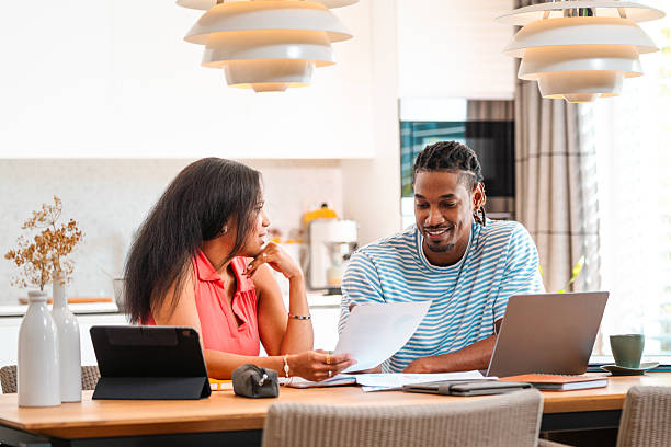 istock Mixed Race Couple Happily Organizing Finances with Technology at Table 2250874427