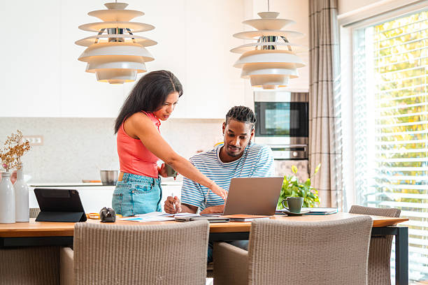 istock Engaged Couple Consulting Financial Papers in Modern Dining Area 2250874477