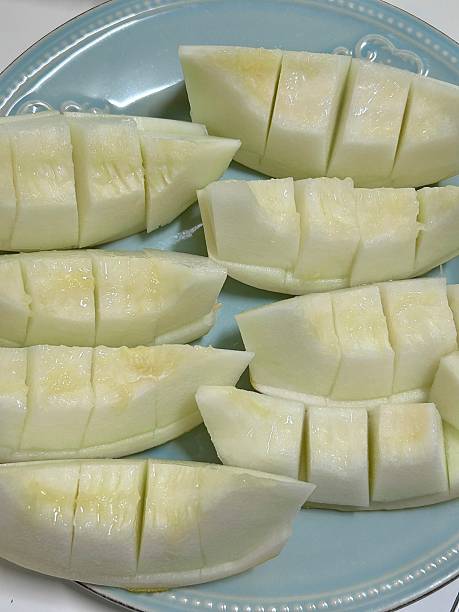 Fresh melon cubes neatly arranged in a bowl, showcasing their vibrant orange and green hues. A refreshing and visually appealing treat, perfect for any occasion.