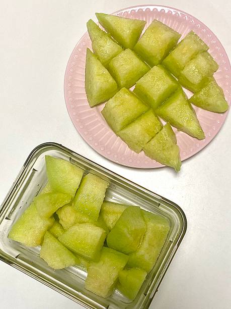 Fresh melon cubes neatly arranged in a bowl, showcasing their vibrant orange and green hues. A refreshing and visually appealing treat, perfect for any occasion.