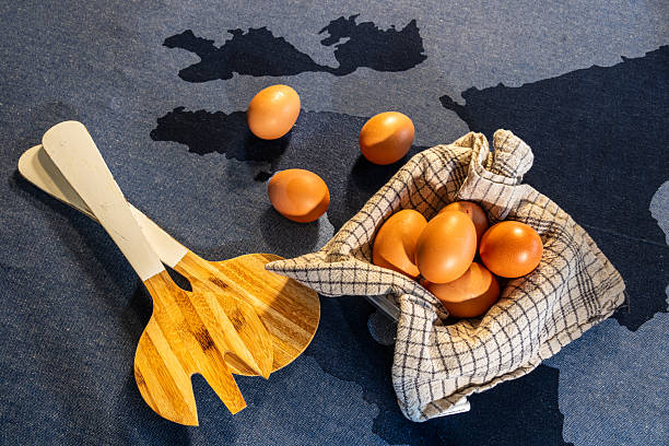 istock brown eggs in cloth with wooden utensils on blue background 2250877159