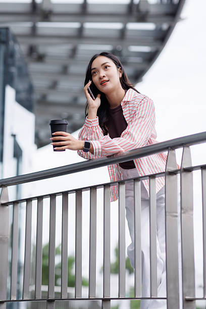 istock Young woman chatting on phone holding coffee 2250877999