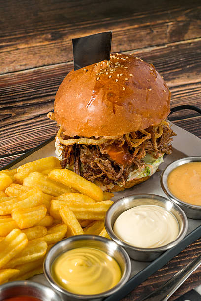 Slow-cooked beef brisket burger served with fries and sauces
