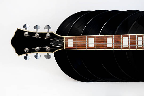 Studio images of a vintage guitar and stacked vinyl records, highlighting musical textures, warm tones and analog nostalgia in a clean, minimal setting.