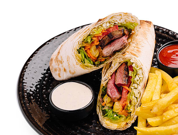 Delicious wrap with grilled steak and fresh veggies served with fries