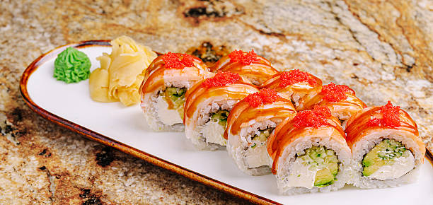 istock Fresh sushi rolls with avocado and salmon on a marble table 2250894517