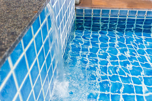 istock Relaxing water feature in a blue tiled swimming pool on a sunny day 2250897775
