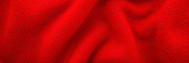 istock Bright red soft wavy knitted fabric background. Closeup. Wide banner. Top down view. 2250897980