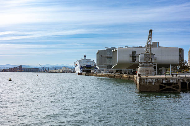 Santander, Spain  Nov 20, 2021: Wide angle view of the modern Centro Botin building next to the historic stone crane (Grua de Piedra) and a docked ferry.