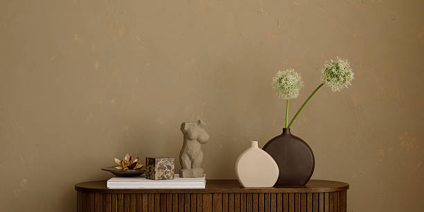 istock Minimalist sideboard with sculptural decor, ceramic vases aand white allium flowers against a textured beige wall. Copy space. 2250901289