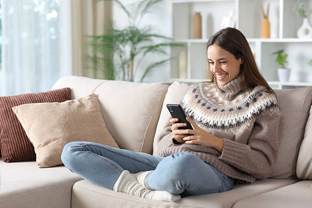 istock Happy woman in winter using smartphone at home 2250903249